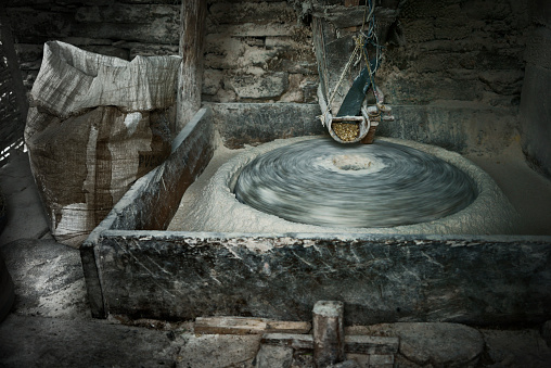 Spinning milling stone of a vintage water mill grinding corn into flour. Close up. XXXL (Sony Alpha 7R)
