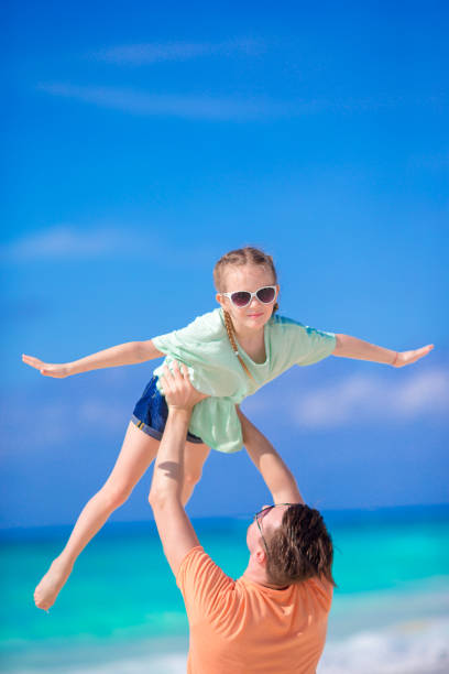 istock Little girl and happy dad having fun during beach vacation 881124870