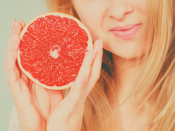 istock Woman holds grapefruit citrus fruit in hands 881165418