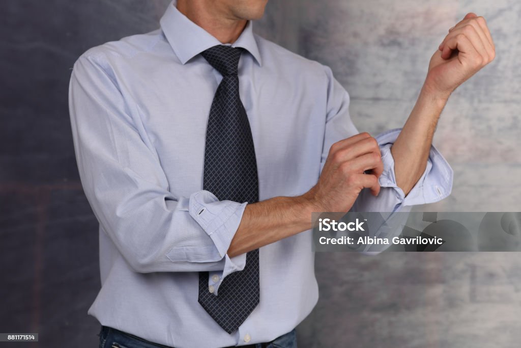 Ready for action. Businessman Rolling Up Sleeves. Sleeve Stock Photo