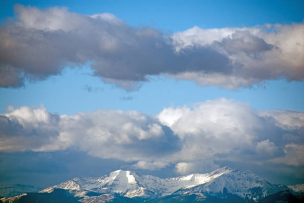 Daybreak Rocky Mountains and cloud formation taken from a distance with the sun on the mountains