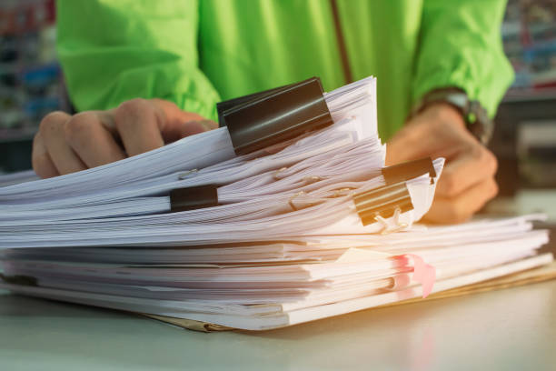 Businessman hands working in Stacks of paper files for searching information on work desk office, business report papers,piles of unfinished documents achieves with clips indoor,Business concept manos de hombre de negocios trabajando en pilas de archivos para buscar información sobre el trabajo de escritorio de oficina, documentos del informe de comerciales, montones de documentos sin terminar logra con el concepto del negocio interior, clips