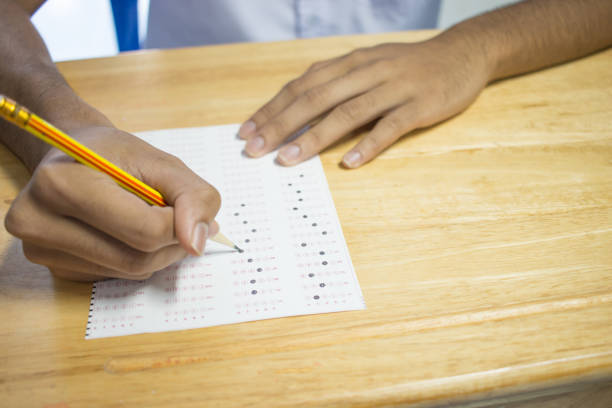 istock Top view of School Asian students taking exams writing answer optical form with pencil in university classroom, view of having exams in class on seat rows, Education test and literacy concept. 881192136
