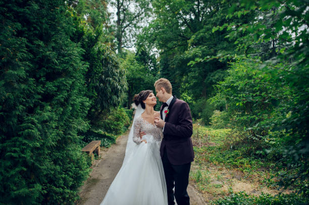 istock Groom catches bride up somewhere in the green park 881210452