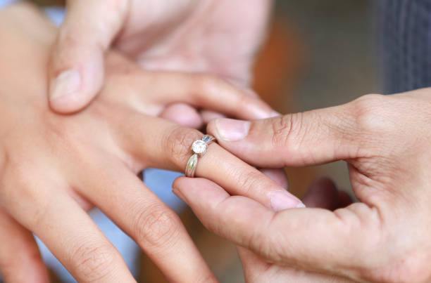 istock Groom wears ring on bride's finger. Selective focus at wedding ring. 881240566