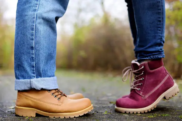 Photo of Closeup photo of male and female legs during a date in autumn park