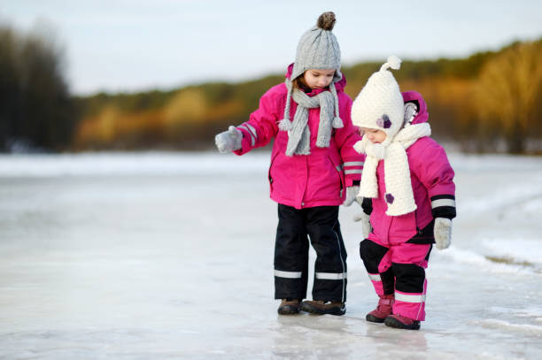 two little sisters having fun on snowy winter day - snow gear imagens e fotografias de stock