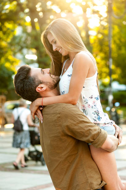 istock Young bearded man lifting up smiling woman 881263558
