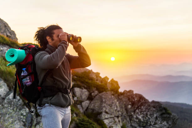 istock Mountaineer looking over the hills through binoculars 881263576