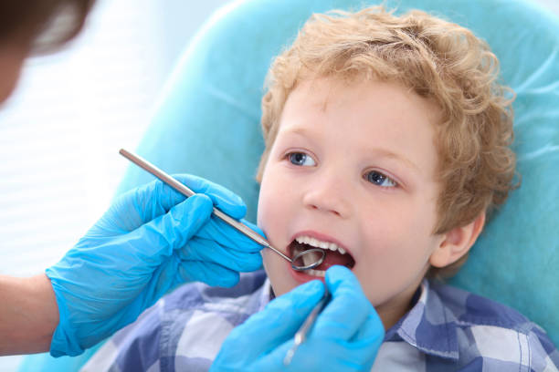männliche zahnarzt untersuchen einen kleinen jungen zähne in der zahnklinik. - human teeth little boys behavior expressing negativity stock-fotos und bilder