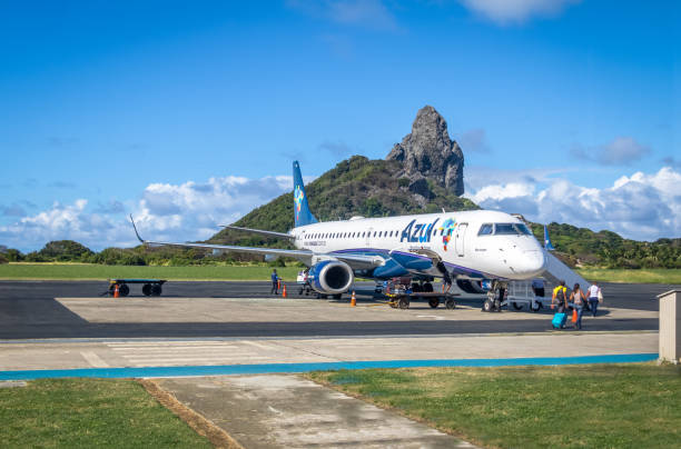 Airplane at Fernando de Noronha Airport with Morro do Pico on background - Fernando de Noronha, Pernambuco, Brazil Fernando De Noronha - Oct 10, 2017: Airplane at Fernando de Noronha Airport with Morro do Pico on background - Fernando de Noronha, Pernambuco, Brazil wow airlines stock pictures, royalty-free photos & images