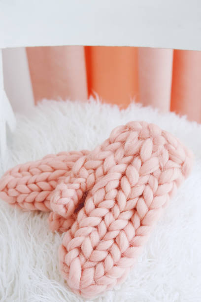 istock Knitted handmade winter accessories. Pink wool mittens. 881276558