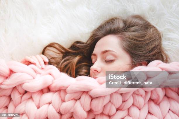 Young Woman With Long Brown Hair Sleeping Under Warm Knitted Peach Color Throw Blanket Stock Photo - Download Image Now