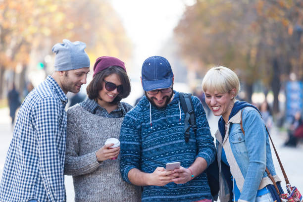 istock Group of young people using smart phones in park 881281102
