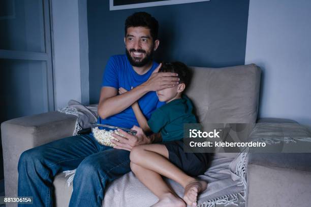 Padre E Hijo Viendo Scary Movie En La Tv Por La Noche Padre Que Cubre Los Ojos De Su Hijo Foto de stock y más banco de imágenes de Adulto