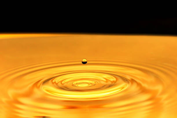 istock a drop of water falls in a golden water. macro 881312310