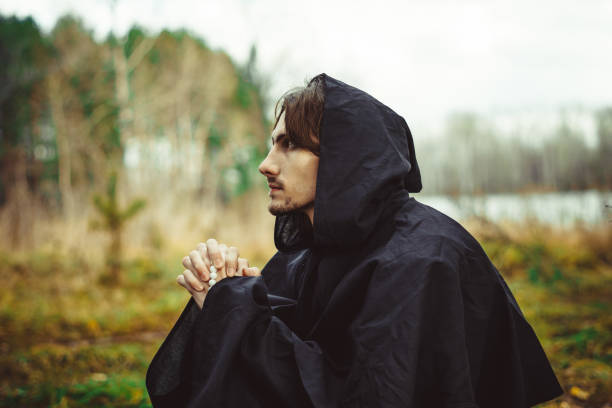 istock a monk in robes praying in the woods 881328736