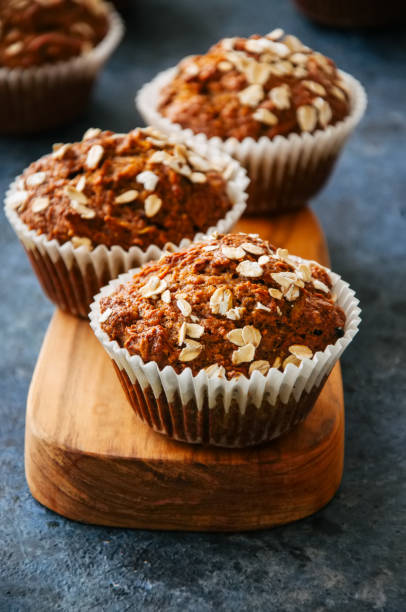 istock Carrot cake muffins with nuts, raisins and oats on a blue stone background. 881337122