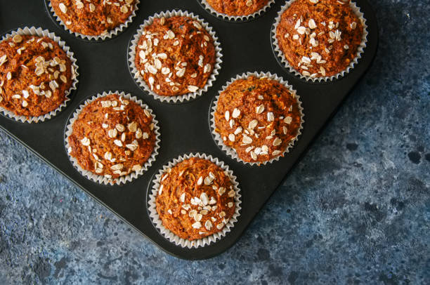 istock Carrot cake muffins with nuts, raisins and oats on a blue stone background. 881337214