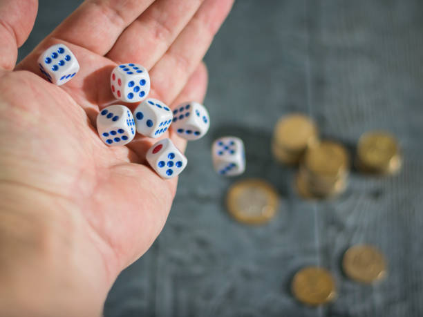istock The man throws the game dice on the table with coins. Money and game cubes. 881355698