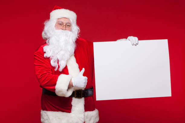 istock Santa Claus pointing in blank advertisement banner isolated on red background with copy space 881355920