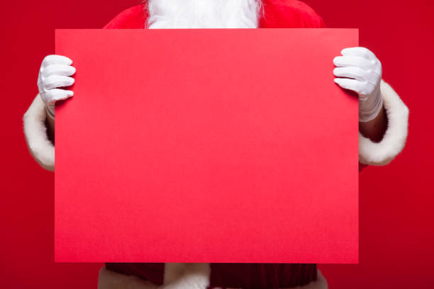 istock Santa Claus pointing in blank advertisement banner isolated on red background with copy space red leaf 881356040