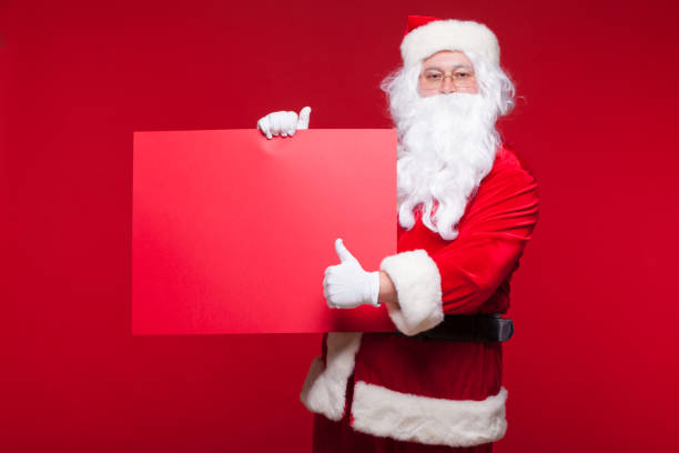 istock Santa Claus pointing in blank advertisement banner isolated on red background with copy space red leaf 881356118