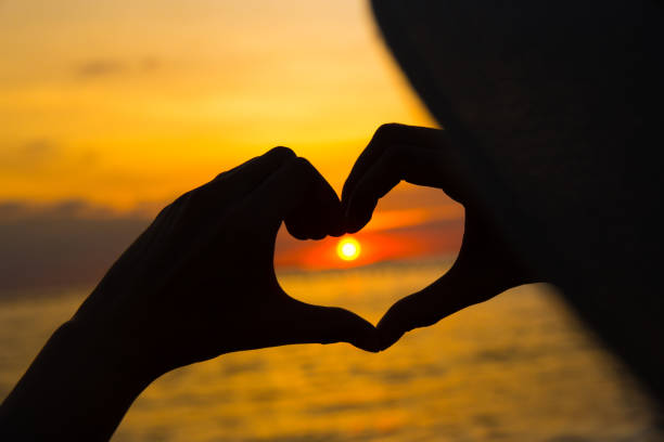 istock hands in heart shape at sunset on beach 881361696