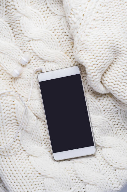 istock Smartphone and headphones over a white sweater 881362188