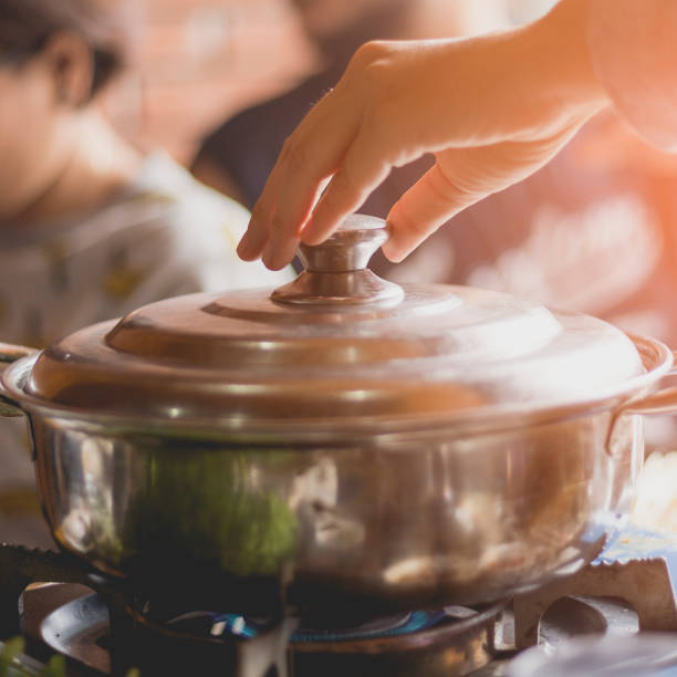istock Woman holding pot lid in the hand for preparing dinner. 881381722