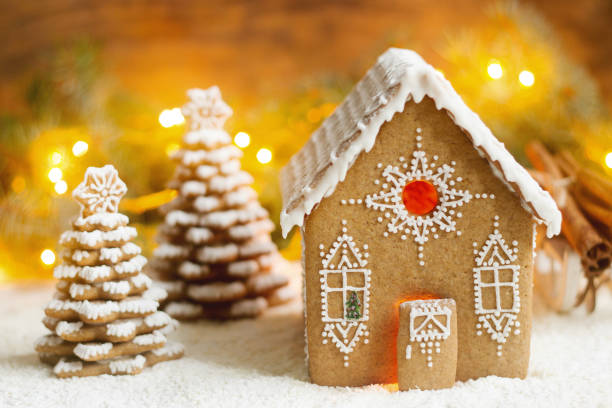 istock Gingerbread house and Christmas trees on a luminous background. Bokeh effect. 881386884