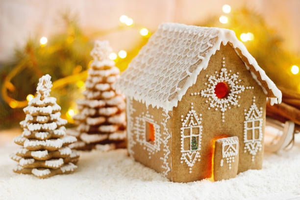 istock Gingerbread house and Christmas trees on a luminous background. Bokeh effect. 881387528