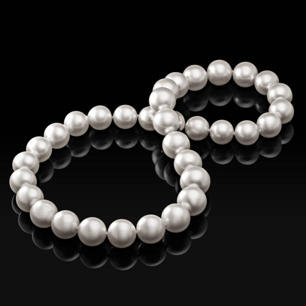 istock Luxury white pearl necklace on a black background with glossy reflection 881418470
