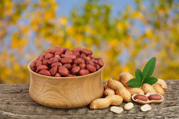 istock peanuts with leaf in bowl on old wooden table with a blurry garden background 881421692