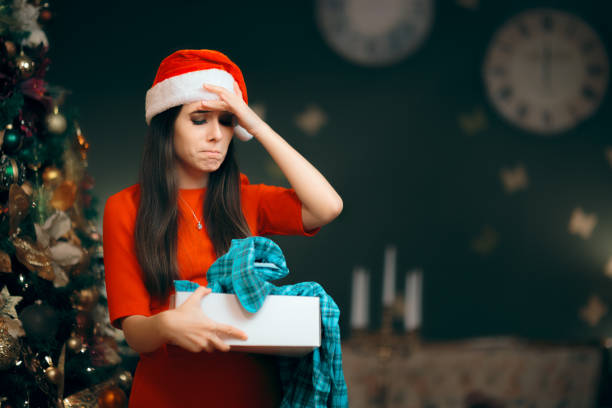 istock Upset Girl Opening a Bad Christmas Gift Finding Pajamas Inside 881425056