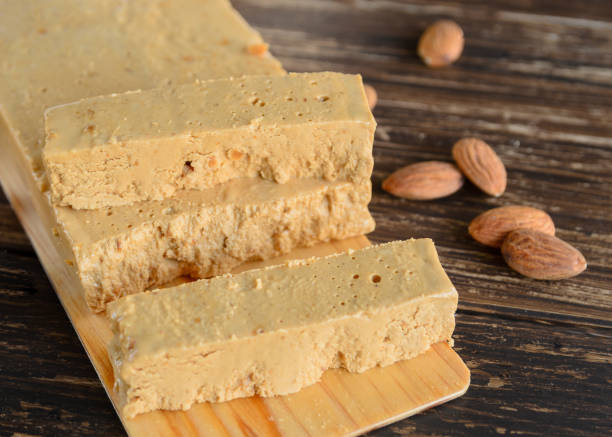 turrón de almendras español en mesa de madera. turrón blando jijona, postre tradicional de navidad en españa. fondo dulce de navidad. - torrone fotografías e imágenes de stock