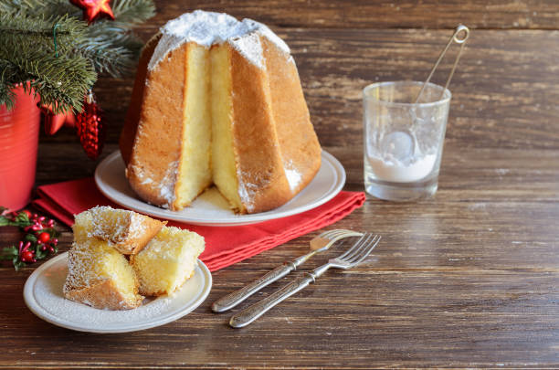 geschnitten sie scheiben von italienischen weihnachten kuchen pandoro mit vanille puderzucker scente. italienische süße hefebrot mit weihnachtsdekoration auf hölzernen hintergrund. textfreiraum - fruitcake christmas christmas cake food stock-fotos und bilder