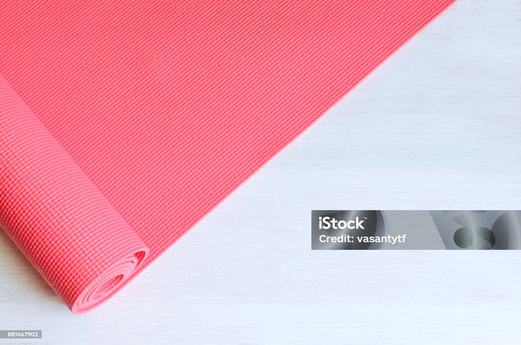 yoga concept Open pink exercise mat on white wooden background.  Concept for practice yoga, pilates or any  physical workout. Exercise Mat Stock Photo