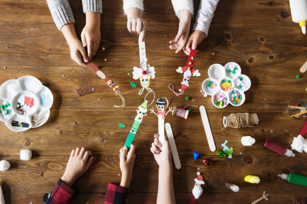 Little kids holding Christmas character decorated popsicle sticks Little kids holding Christmas character decorated popsicle sticks typebar stock pictures, royalty-free photos & images