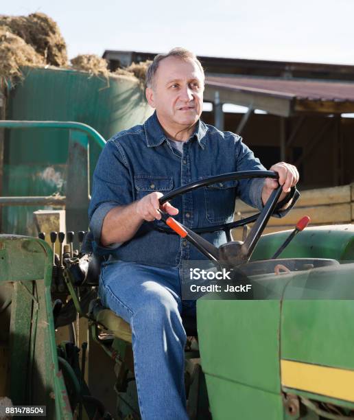 Senior Aged Man Working On Small Farm Tractor Stock Photo - Download Image Now - 50-54 Years, AIDS, Adult