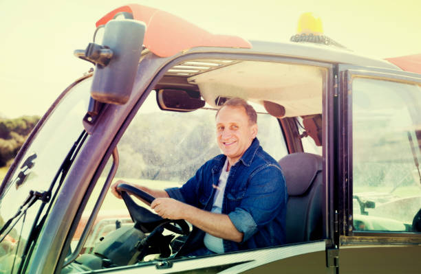 istock Senior aged man working on small farm tractor 881478554