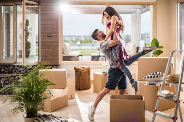 istock Young playful couple having fun while moving into new penthouse. 881480924