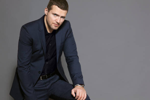 istock a man in a blue suit is sitting on a gray background studio 881484024