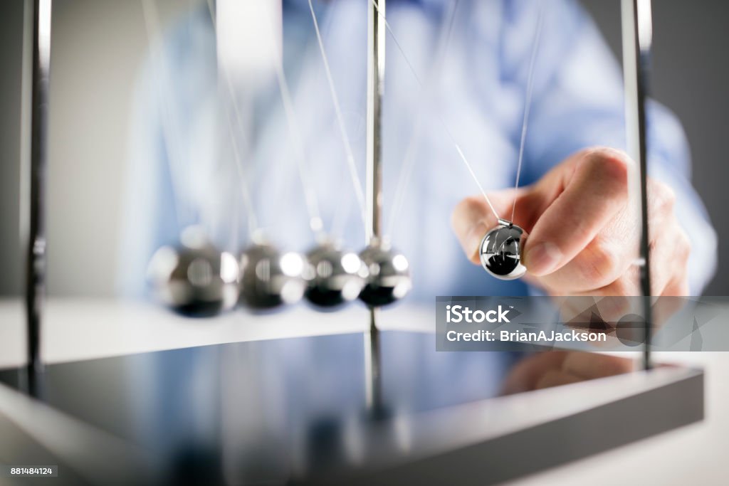 Newton's cradle businessman concept for cause and effect Newton's cradle businessman releasing ball concept for cause and effect Impact Stock Photo