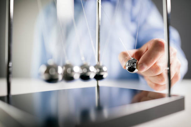 Newton's cradle businessman concept for cause and effect Newton's cradle businessman releasing ball concept for cause and effect perpetual motion stock pictures, royalty-free photos & images