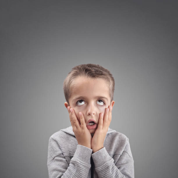 Shocked and surprised child fed up, bored or showing despair Shocked, surprised child fed up, bored or showing despair head in hands stock pictures, royalty-free photos & images