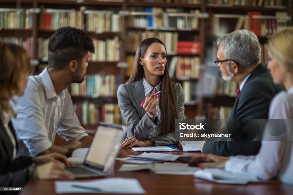 Imprenditrice che parla con il suo team di nuove idee imprenditoriali in un incontro. - Foto stock royalty-free di Abbigliamento da lavoro formale