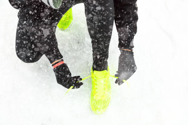istock Tying running shoes on the freezing snow. 881484490
