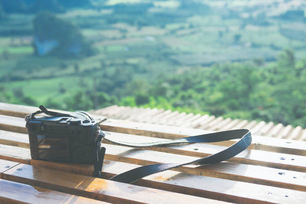 istock Mirrorless camera put the wooden table with beautiful scenery view below in the morning. 881487742