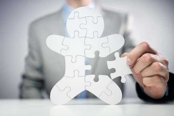 Businessman assembling jigsaw puzzle human team employee Businessman assembling jigsaw puzzle human team employee concept psyche photography stock pictures, royalty-free photos & images